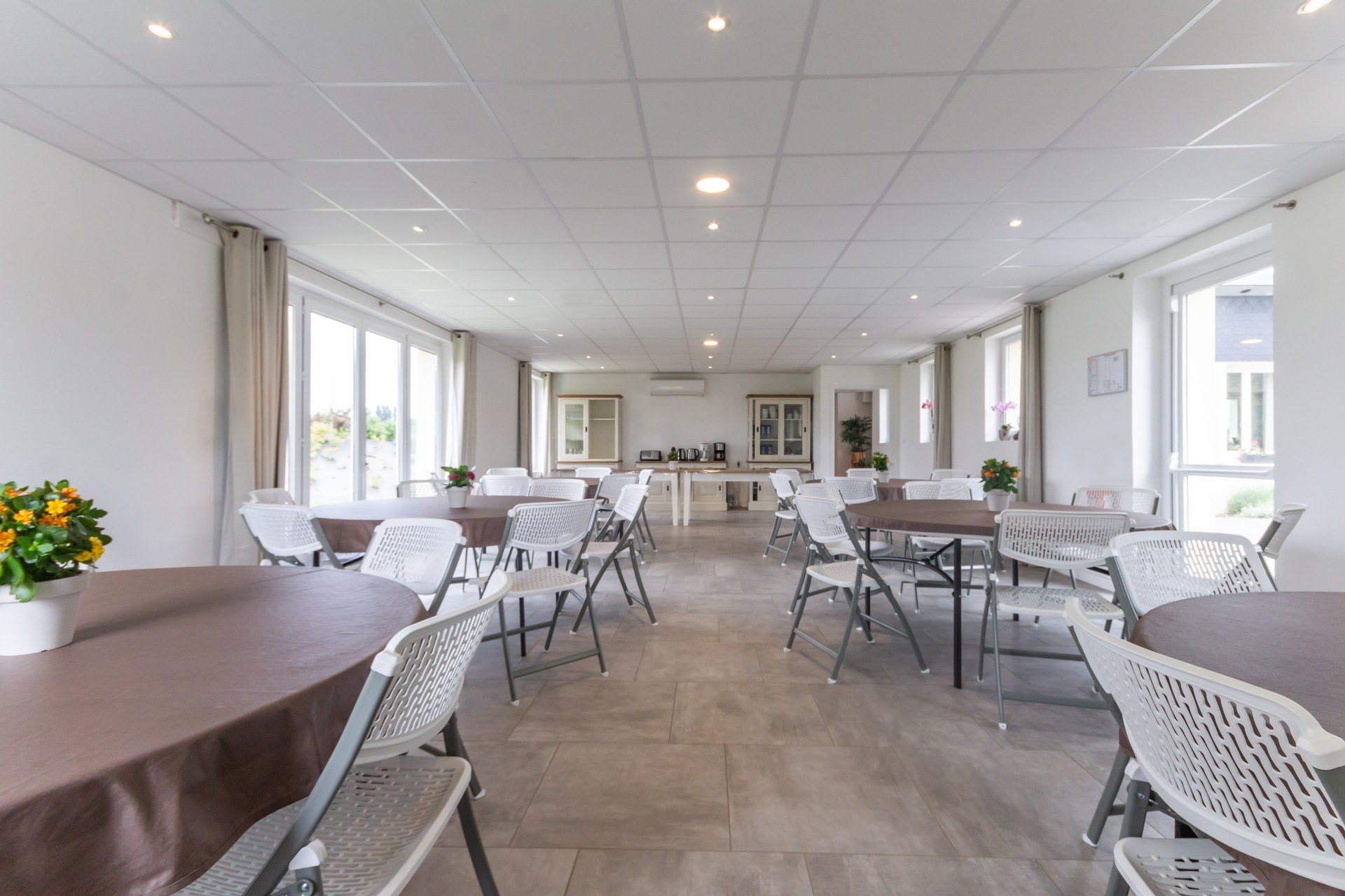 Salle de restauration avec tables rondes et rectangulaires